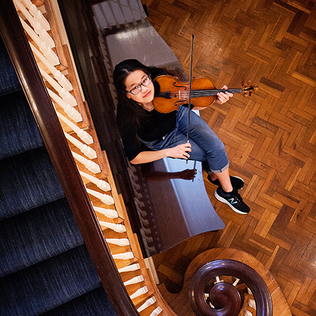Girl Playing Violin By Stairs