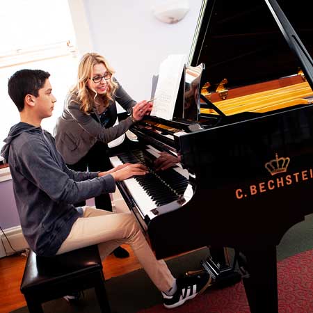 student and faculty at piano