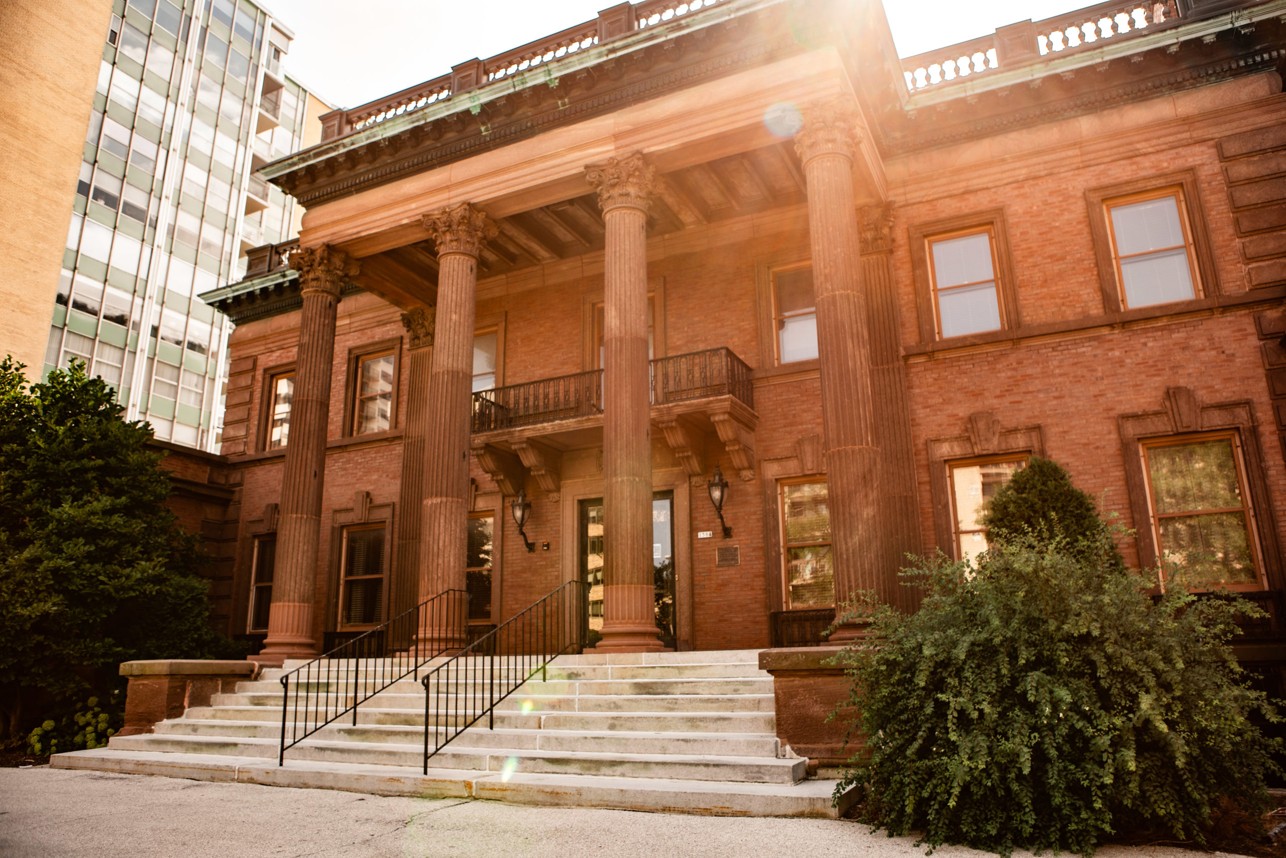The McIntosh/Goodrich mansion with the sun beaming from behind the building.